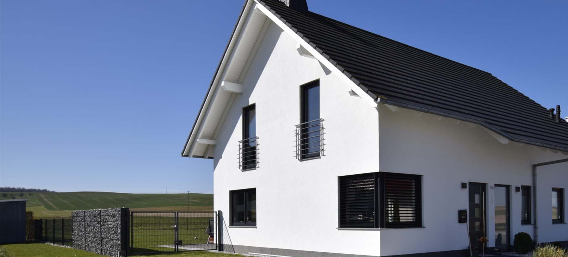 Ein weißes Massivhaus mit Garten
