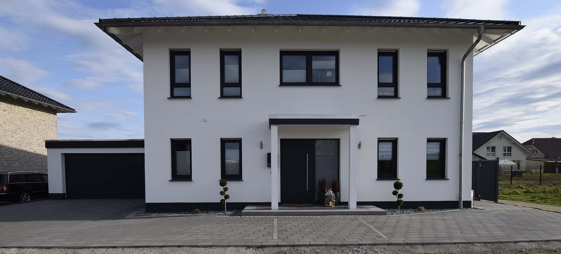 Ein weißes Massivhaus mit Garage